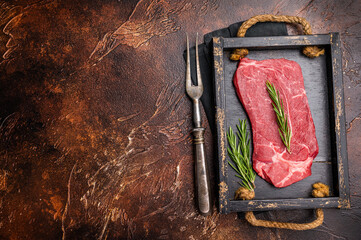 Fresh butchered Raw top sirloin beef steak with rosemary. brown background. top view