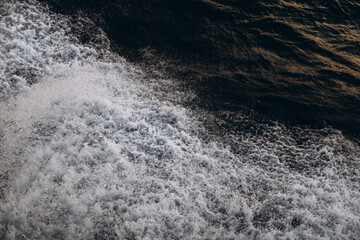 A close-up, abstract view of churning sea foam and waves, showing the dynamic texture and movement...