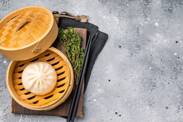 Chinese Bao or Baozi bun with meat in bamboo steamer. grey background. top view