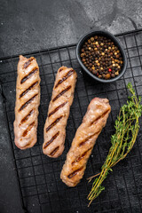 BBQ Grilled beef and pork sausages on steel rack. black background. top view