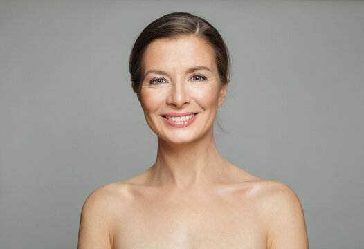 Glorious mid aged mature woman looking at camera and smiling. Healthy face skin care beauty - Powered by Adobe