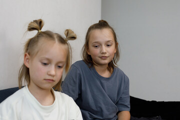 Portrait of 6 and 11 year old blond sibling. Young brother looking at little sister