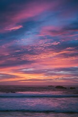 Obraz premium Vibrant sunset over the ocean with dramatic clouds.