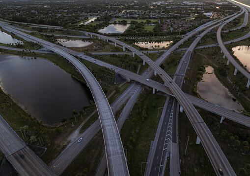 Aerial view of the intricate sawgrass highway interchange reflecting the sky, with water bodies reflecting the sunset, creating a tapestry of light and shadow, Sunrise, Florida, United States.
