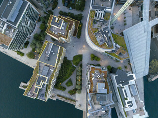 Aerial view of modern buildings with green roofs and sleek architectural designs meet the serene waterfront in a stunning urban landscape, Oslo, Oslo, Norway.