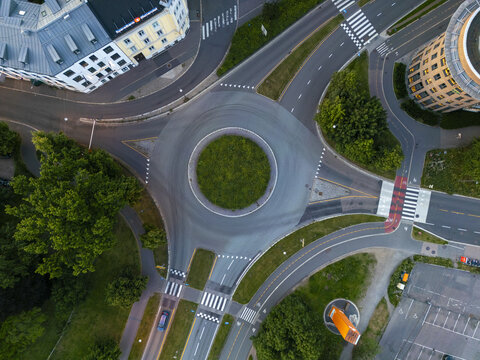 Aerial view of a roundabout's circular green heart amidst the concrete arteries and zebra crossings, nestled within buildings and greenery, Oslo, Oslo, Norway.