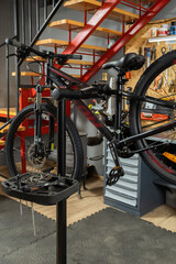 Modern mountain bike mounted on repair stand in workshop with tools