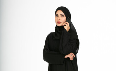 Portrait of an arab woman on a white background talking on her mobile.