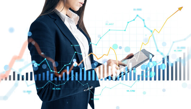Woman in business suit using a tablet with forex and stock market charts overlaid, on white background. Concept of digital financial analysis