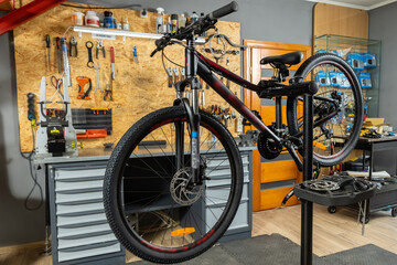 Black bike fixed for repair in organized maintenance space