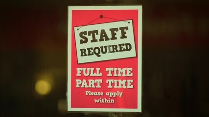 Poster announcing staff required placed on glass door of business. Sign showing hiring message with text staff required full time part time please apply within. Notice inviting job seekers to inquire