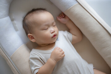 small baby sleeping quietly in bedroom crib