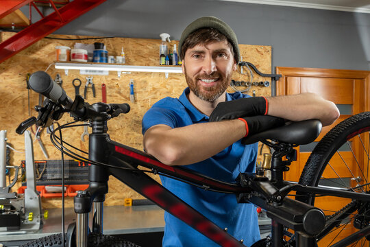 Bearded bike repair specialist working in organized workshop - Powered by Adobe
