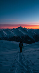 Obraz premium Solo Winter Hiker at Sunset in the Majestic Mountains