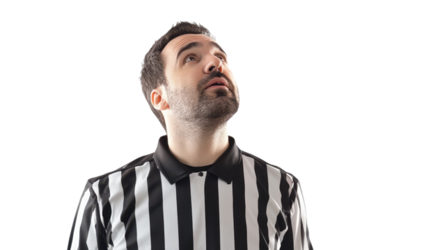 Referee dressed in a black and white striped jersey gazes upward, showing focus and determination in a vibrant area