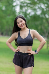 Young asian athlete smiling and posing in park wearing sportswear