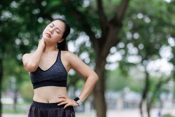 Young sporty woman suffering neck pain after workout in a park
