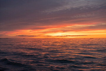 Asnelles-Sur-Mer, France - 08 08 2025: Panoramic view the sea, waves and the colorful cloudy sky at sunset