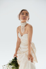 Elegant bride in a stunning white wedding dress showcasing timeless beauty in studio