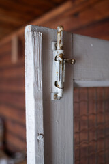 Rustic barn door latch. Latch on a wooden door with a glass panel. Antique latch. Latch on a wooden...