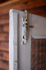 Rustic barn door latch. Latch on a wooden door with a glass panel. Antique latch. Latch on a wooden...