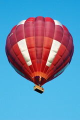 Fototapeta premium A hot air balloon in flight against a clear blue sky.