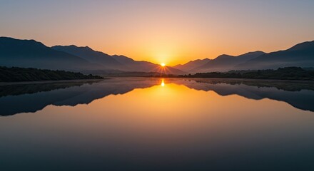 Fototapeta premium Golden Sunrise Reflected on Calm Lake with Mountain Silhouette