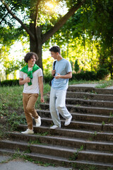 Two teens walking in the park after school and looking contented