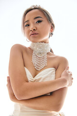 Young bride in elegant wedding dress showcases beauty in a serene studio environment