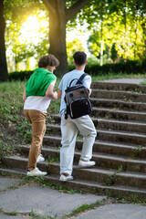 Two teens walking in the park after school and looking contented