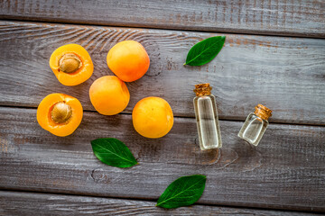 Fruit aroma oil. Apricot kernel oil on dark wooden background top view