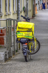 A delivery man's parked electric scooter on a summer day