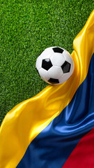A soccer ball on a green field with a Colombian flag. High quality photo