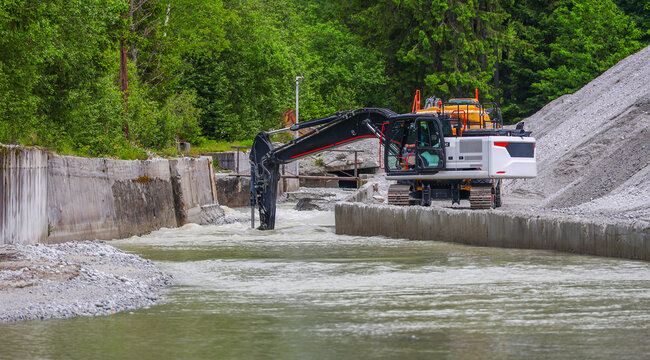 Image of a new excavator working to strengthen the embankment. Hydraulic excavator working on the river bank.