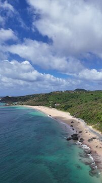 Vis&atilde;o a&eacute;rea da Praia da Concei&ccedil;&atilde;o em Fernando de Noronha com canoas pr&oacute;ximas ao Morro do Pico, mar cristalino e paisagem tropical preservada do arquip&eacute;lago