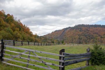 Wooden fence leading to autumn colored hills in the countryside