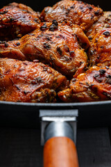 Baked chicken thighs on a cast iron grill pan with a crispy crust