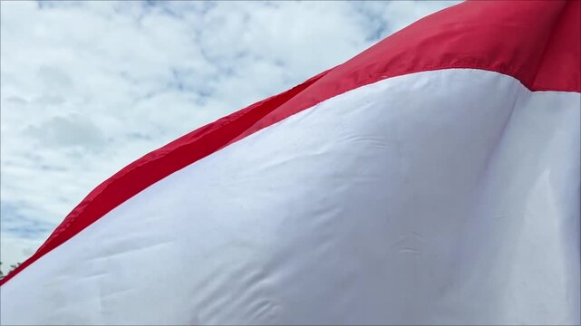 The Indonesian flag is waving against the sky