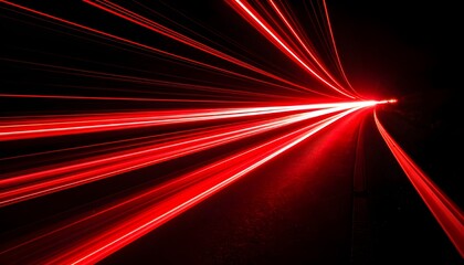 Fototapeta premium Long exposure of red light trails curving against a black background,