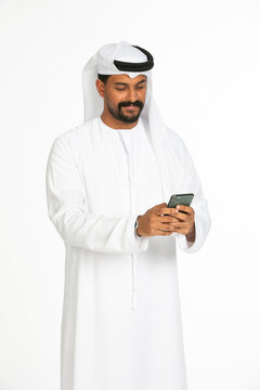 Portrait of an emirati man on a white background using mobile.
