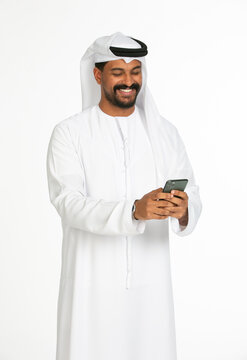 Portrait of an emirati man on a white background using mobile.