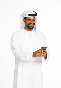 Portrait of an emirati man on a white background using mobile.