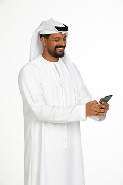 Portrait of an emirati man on a white background using mobile.