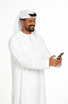 Portrait of an emirati man on a white background using mobile.