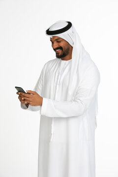 Portrait of an emirati man on a white background using mobile.