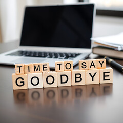 Saying Goodbye Wooden blocks spelling Time To Say Goodbye on a desk near a laptop and notebook signifying farewell departure or end of a chapter with soft natural lighting and a blurred background
