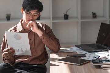 Focused Young Man Analyzing Data in Modern Office Setting