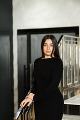 girl in black dress on steps indoors