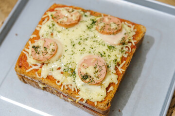 Homemade pizza made from white bread with sausage and cheese toppings
