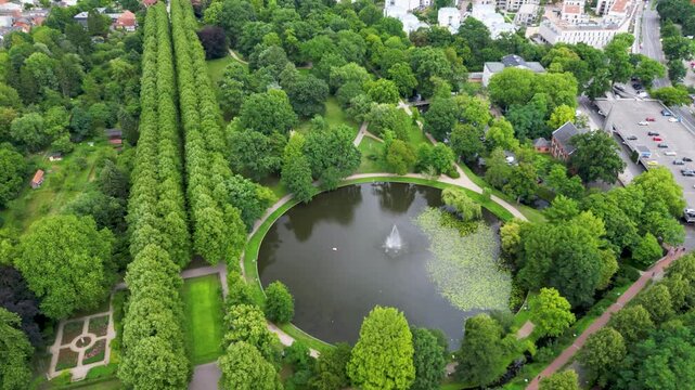 Aerial view of the French Garden and serene pond with fountain, showcasing the lush greenery and formal garden design, Celle, Lower Saxony, Germany.